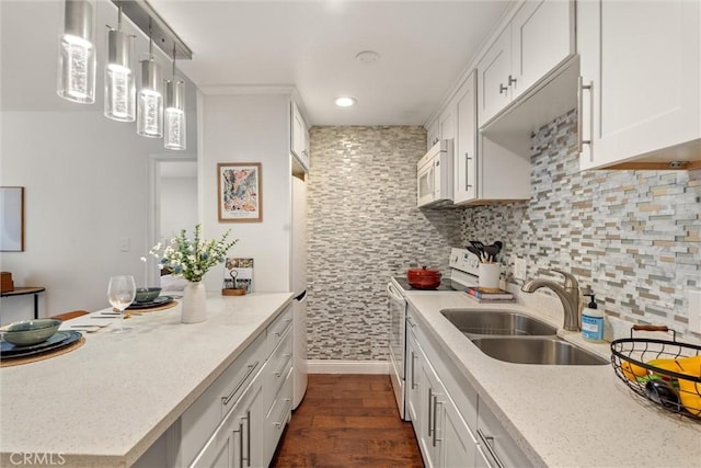 kitchen featuring white cabinetry, sink, white appliances, and hanging light fixtures