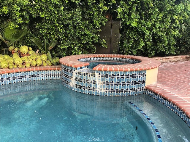 view of swimming pool featuring an in ground hot tub