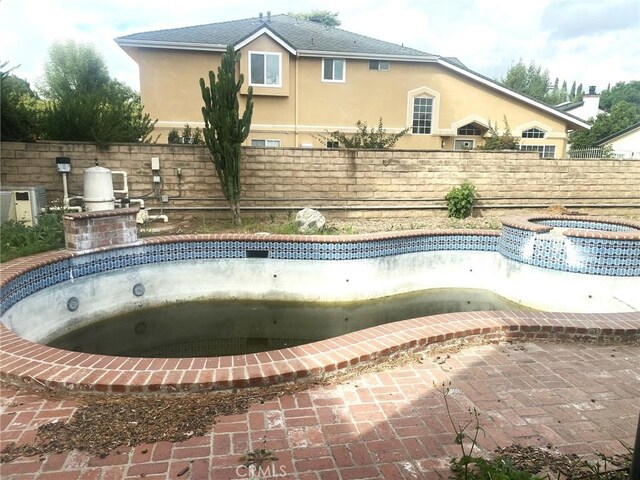 view of swimming pool with an in ground hot tub