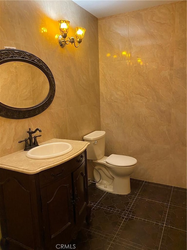 bathroom featuring vanity, tile walls, and toilet