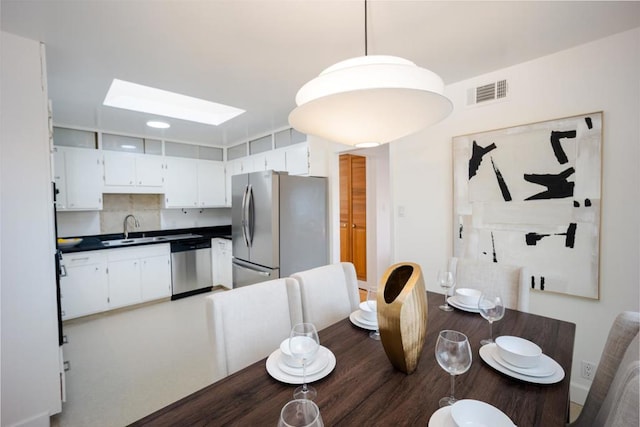 dining room with a skylight and sink