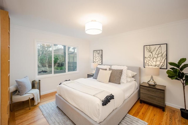 bedroom with ornamental molding and light wood-type flooring