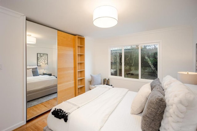 bedroom with hardwood / wood-style floors and crown molding