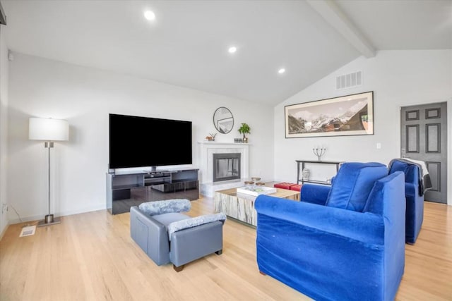 living room featuring light hardwood / wood-style flooring and vaulted ceiling with beams