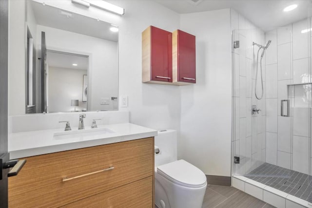 bathroom featuring vanity, an enclosed shower, and toilet