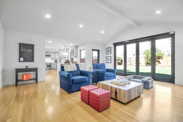 living room featuring light hardwood / wood-style flooring and vaulted ceiling with beams