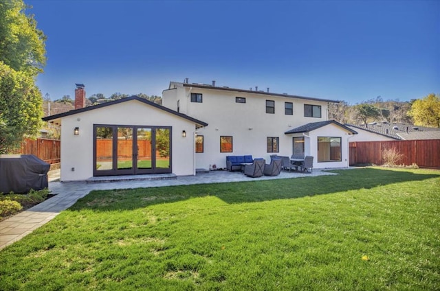 back of property with a yard and a patio area