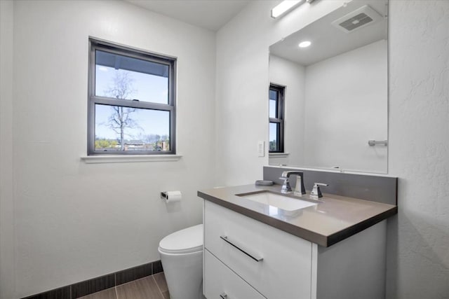 bathroom featuring vanity and toilet