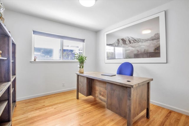 home office with light hardwood / wood-style flooring