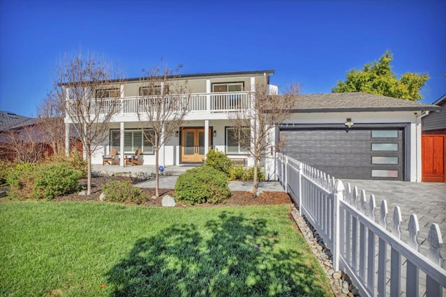 view of front of property with a garage, a front lawn, and a balcony