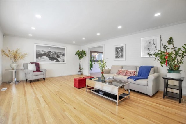 living room featuring wood-type flooring and crown molding