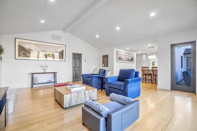 living room featuring vaulted ceiling with beams and light hardwood / wood-style floors