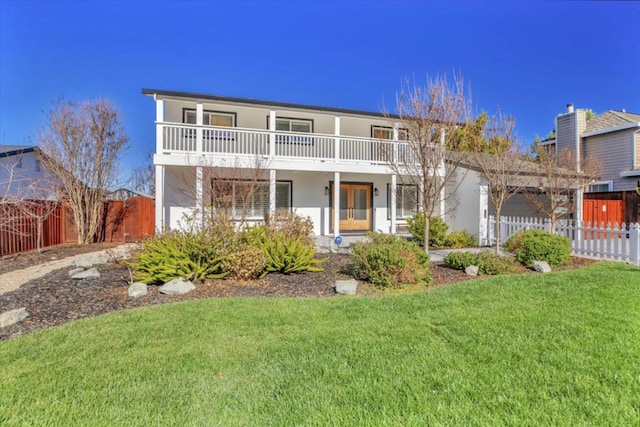 front of property featuring a front yard and a balcony