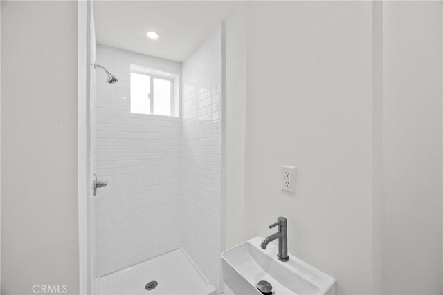 bathroom featuring sink and a tile shower