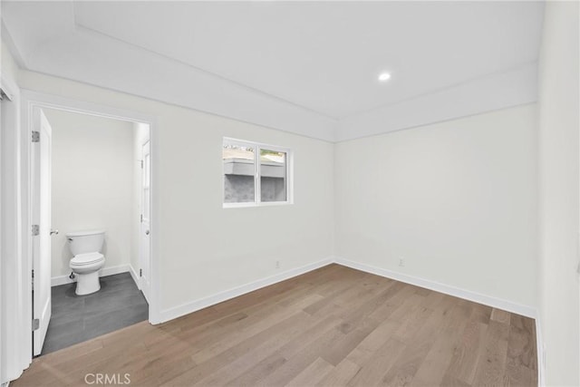 unfurnished bedroom featuring connected bathroom and light hardwood / wood-style flooring