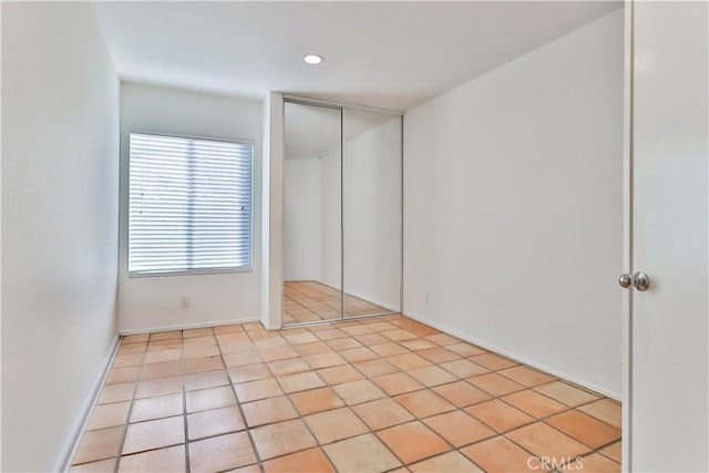 unfurnished bedroom with light tile patterned floors and a closet