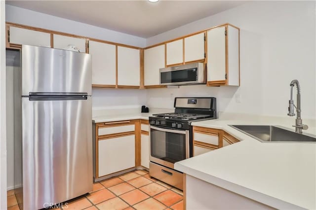 kitchen with white cabinetry, sink, light tile patterned floors, and stainless steel appliances