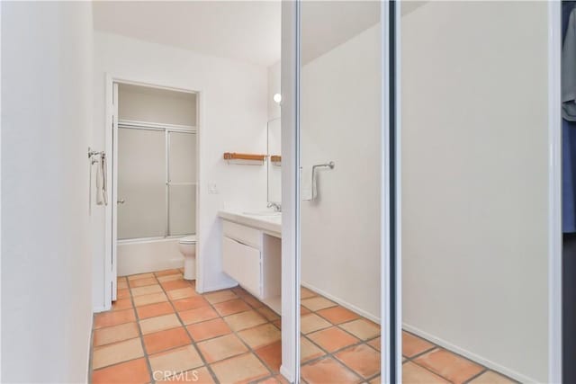 full bathroom featuring vanity, tile patterned flooring, shower / bath combination with glass door, and toilet