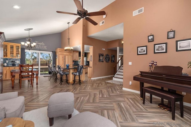 living room with dark parquet flooring, ceiling fan with notable chandelier, and high vaulted ceiling