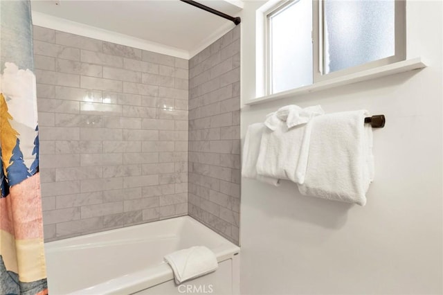 bathroom with ornamental molding and tiled shower / bath