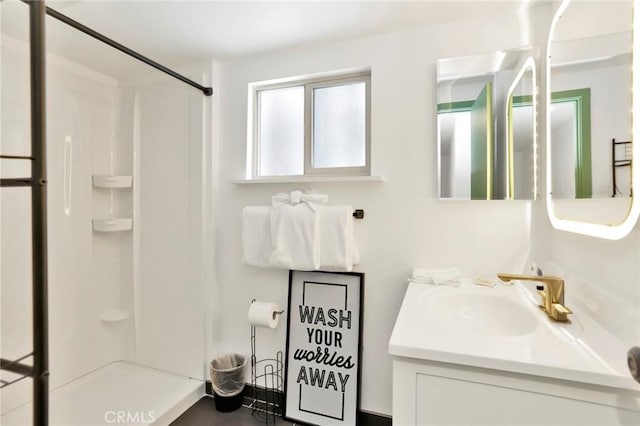 bathroom with walk in shower and vanity