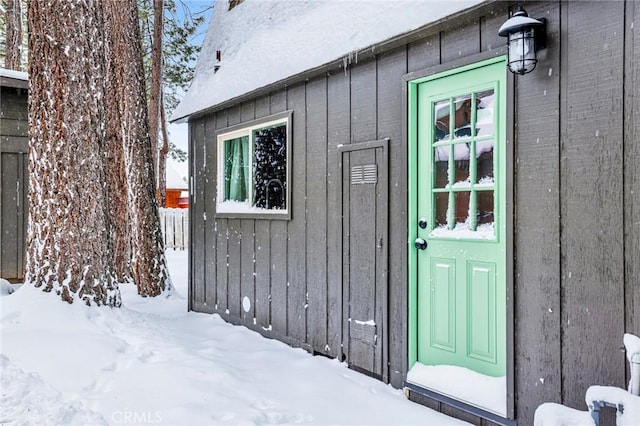 snow covered property entrance with fence