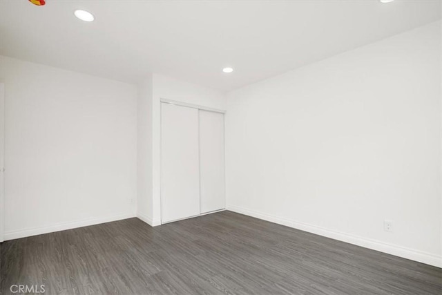 empty room with dark hardwood / wood-style flooring