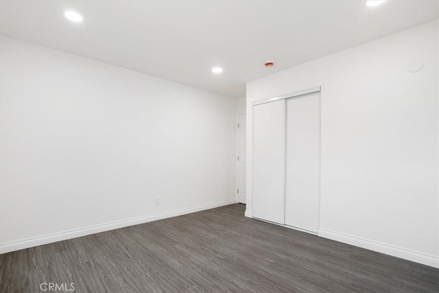 unfurnished bedroom featuring a closet and dark hardwood / wood-style floors