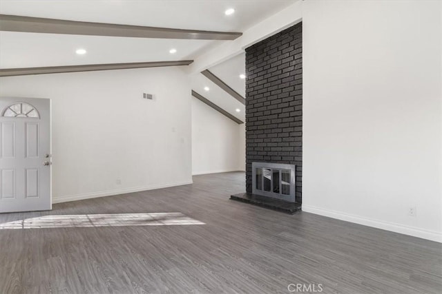 unfurnished living room featuring dark wood-type flooring, a fireplace, and lofted ceiling with beams