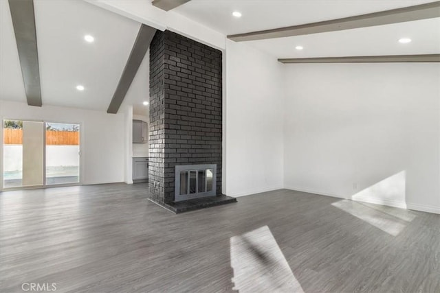 unfurnished living room featuring wood-type flooring, vaulted ceiling with beams, and a fireplace