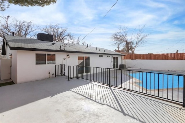 back of house with a fenced in pool, central AC unit, and a patio area