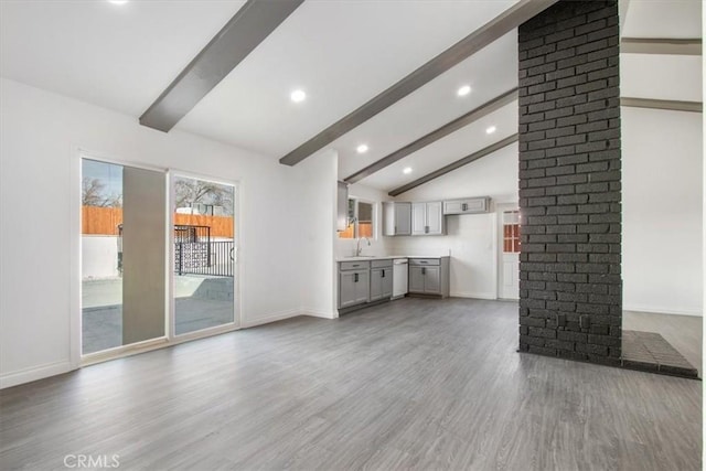 unfurnished living room with beamed ceiling, high vaulted ceiling, sink, and hardwood / wood-style flooring