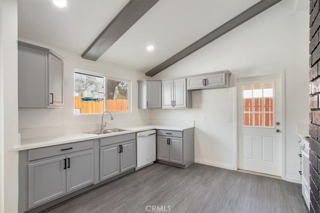 kitchen featuring gray cabinets, dishwasher, sink, and lofted ceiling with beams