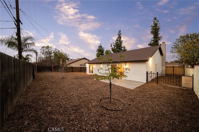 yard at dusk with a patio area