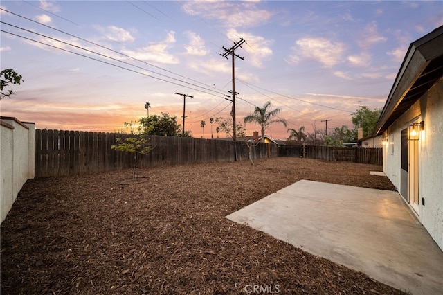 yard at dusk featuring a patio area