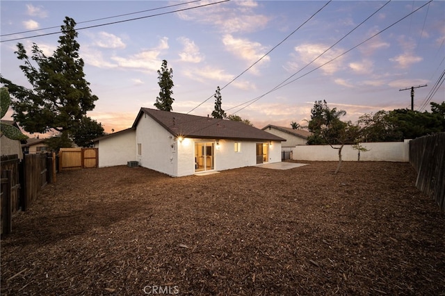 back house at dusk with a patio area