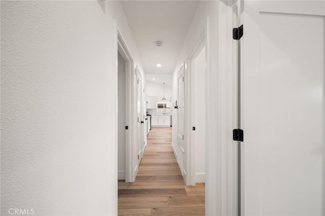 corridor with light hardwood / wood-style flooring