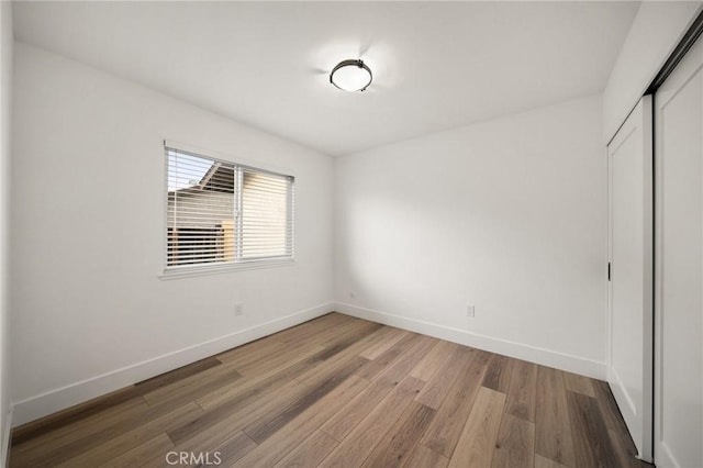 unfurnished bedroom with hardwood / wood-style floors and a closet