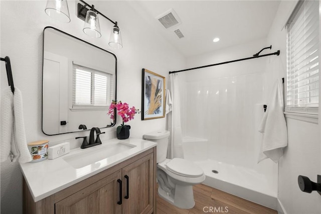 bathroom with wood-type flooring, toilet, curtained shower, and vanity