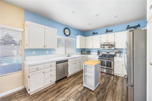 kitchen with white cabinetry, dark wood-type flooring, and stainless steel appliances