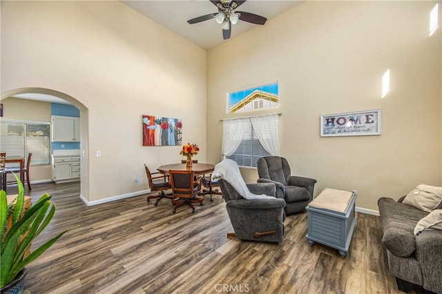 sitting room featuring dark hardwood / wood-style floors, ceiling fan, and a high ceiling