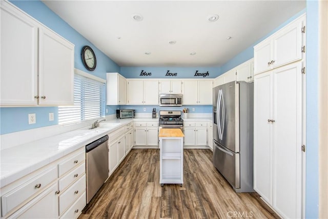 kitchen with white cabinetry, sink, stainless steel appliances, and dark hardwood / wood-style floors