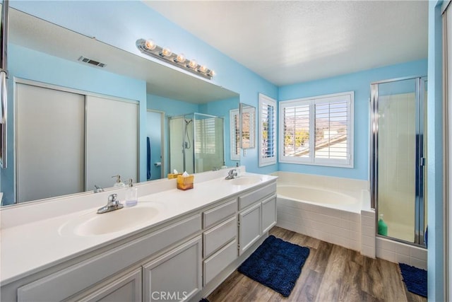 bathroom featuring vanity, separate shower and tub, and hardwood / wood-style floors