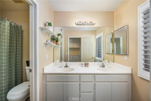 bathroom featuring vanity, toilet, and walk in shower