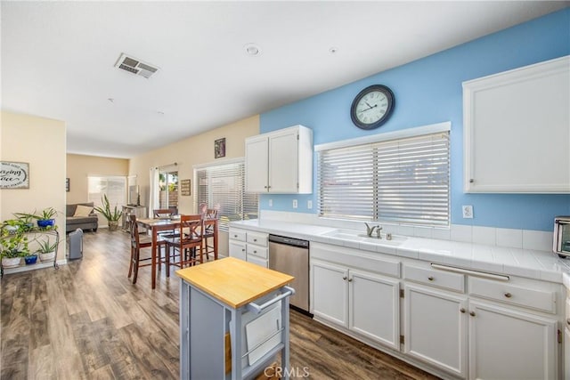 kitchen with dishwasher, sink, tile counters, and white cabinets