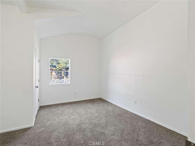 unfurnished room featuring carpet floors and vaulted ceiling