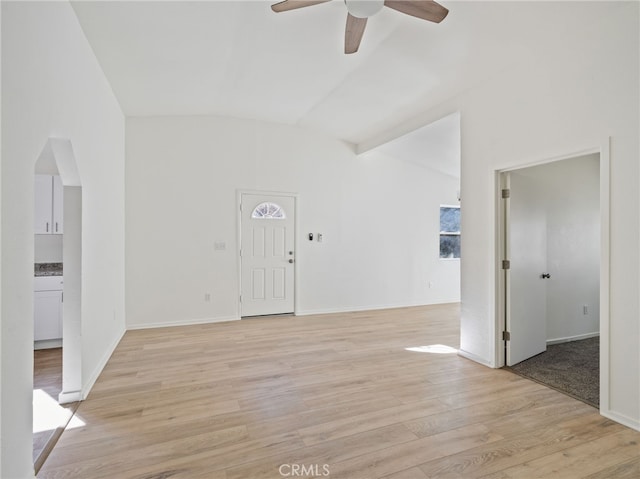 empty room with vaulted ceiling, ceiling fan, and light hardwood / wood-style floors