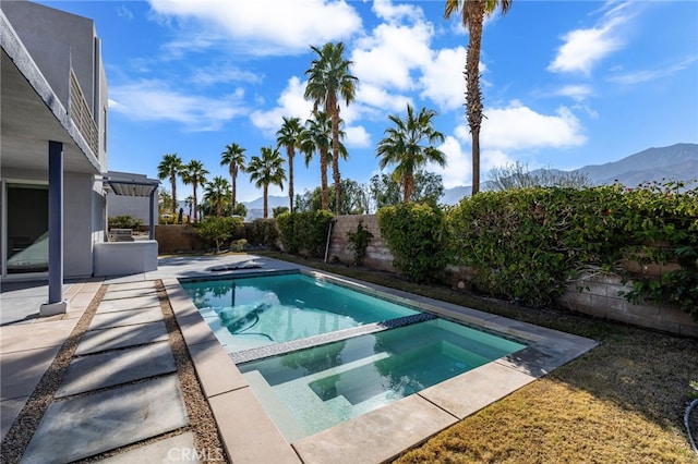 view of pool with an in ground hot tub, a mountain view, and a patio