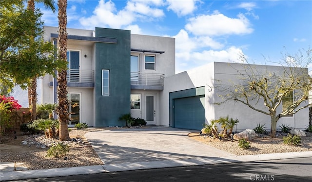 contemporary house featuring a garage and a balcony