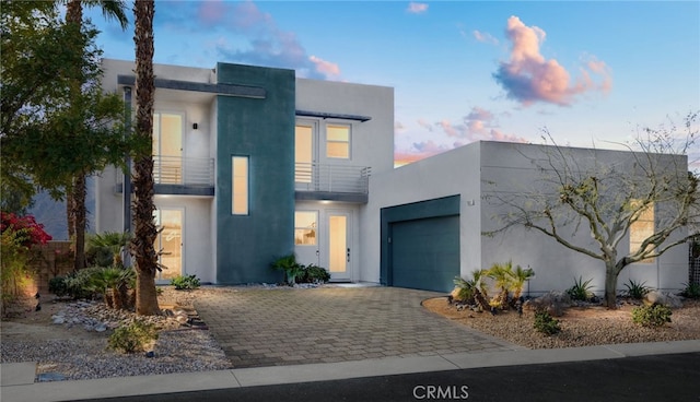 contemporary house featuring a garage and a balcony